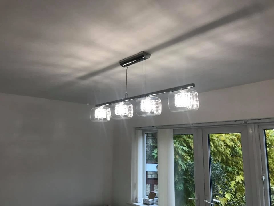 a light fixture with four lights from the ceiling