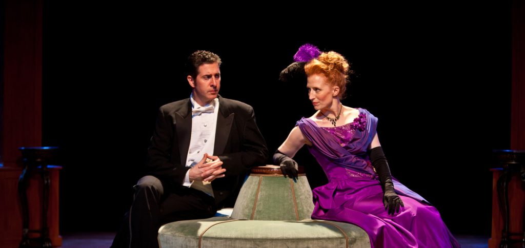 a man and woman sitting on a stage
