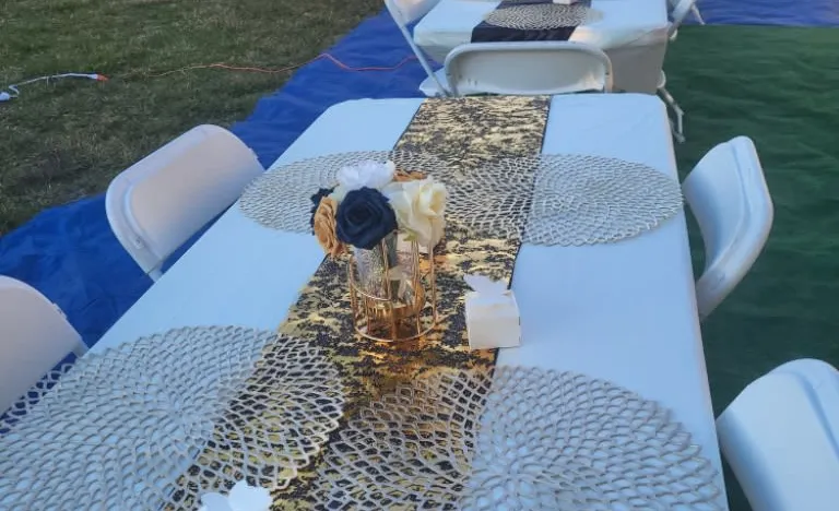 a table with white and blue tablecloths and white chairs