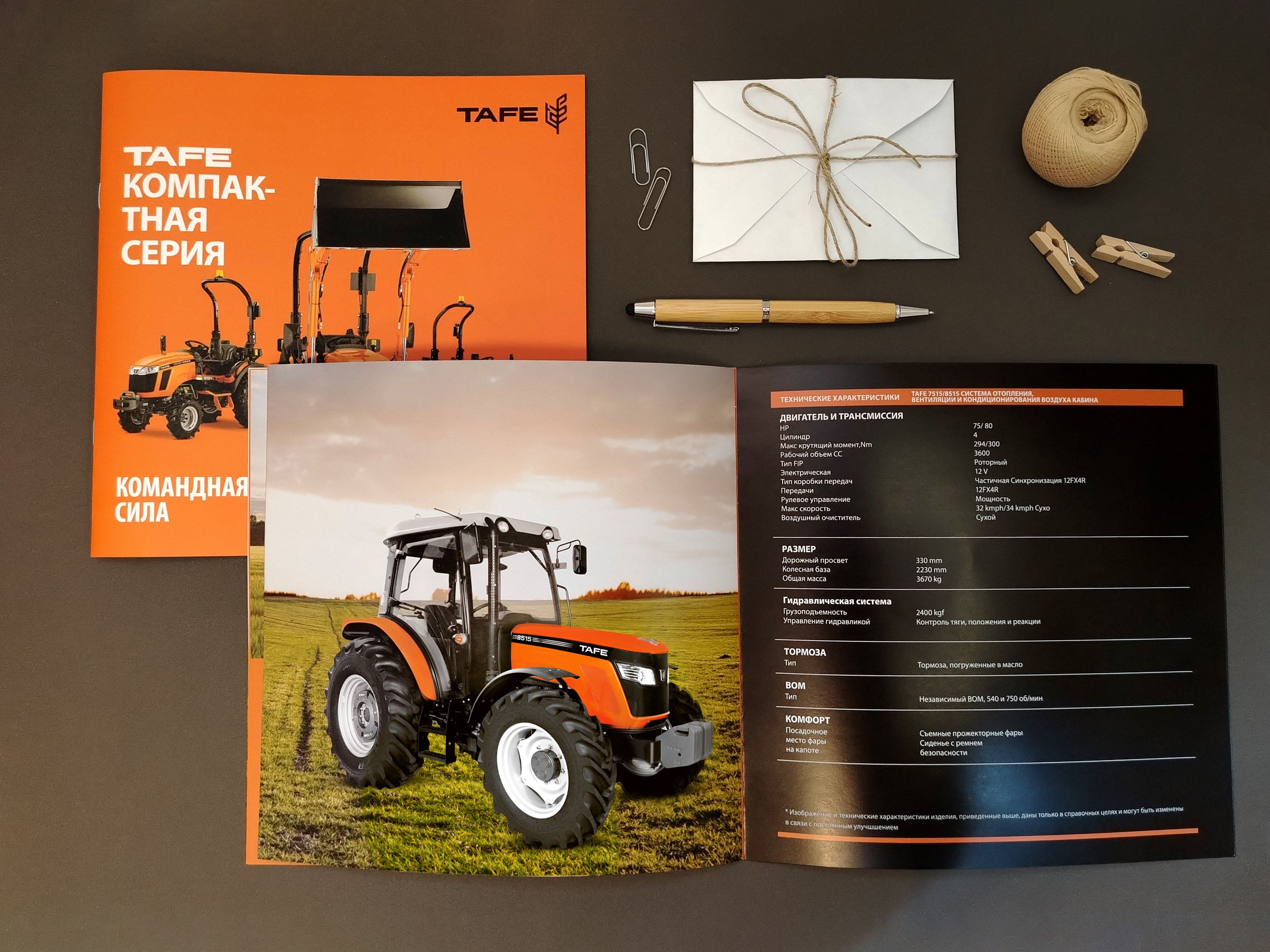 a brochure with a picture of a tractor and a pen and envelope