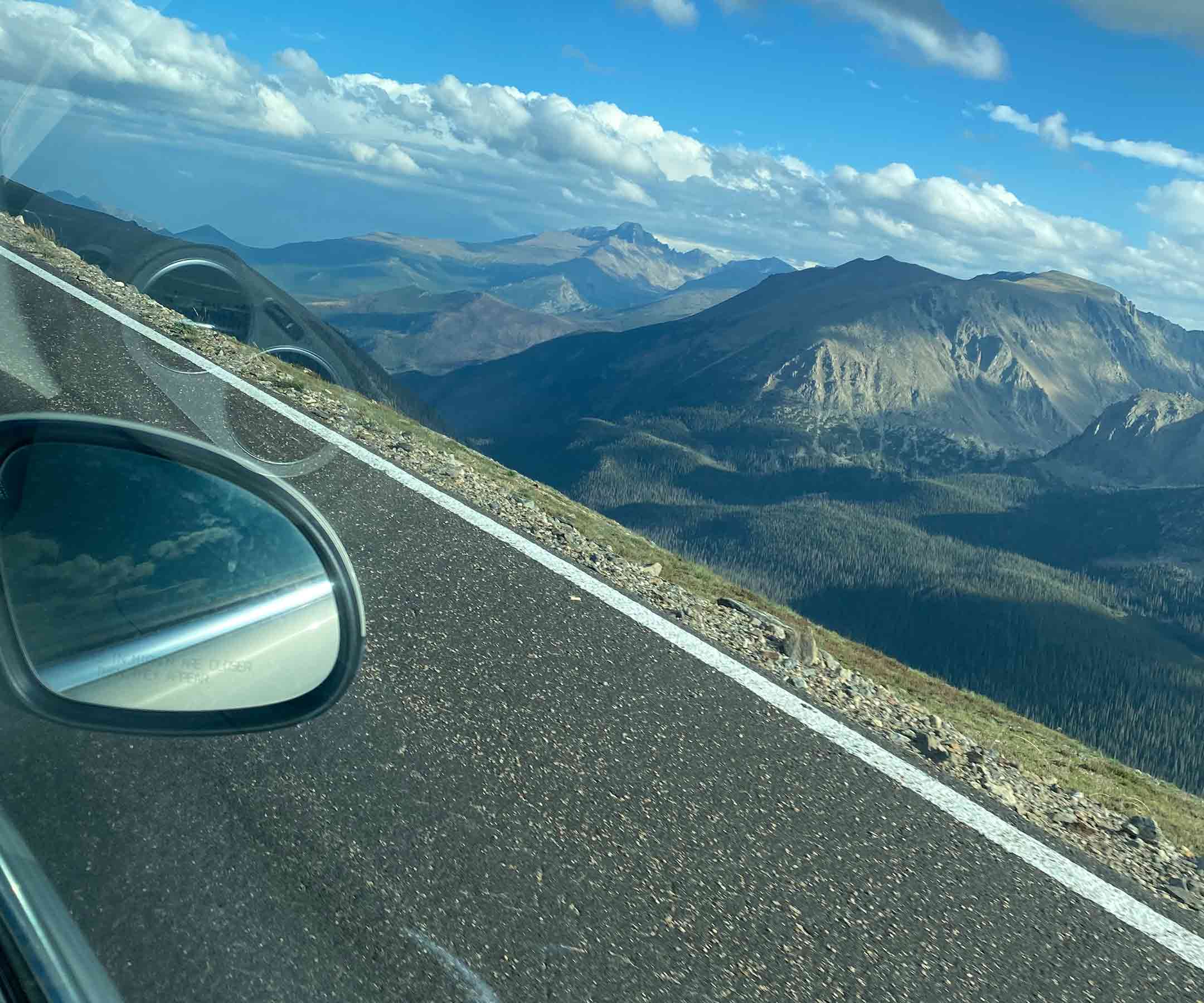 a view of a road and mountains from a car window