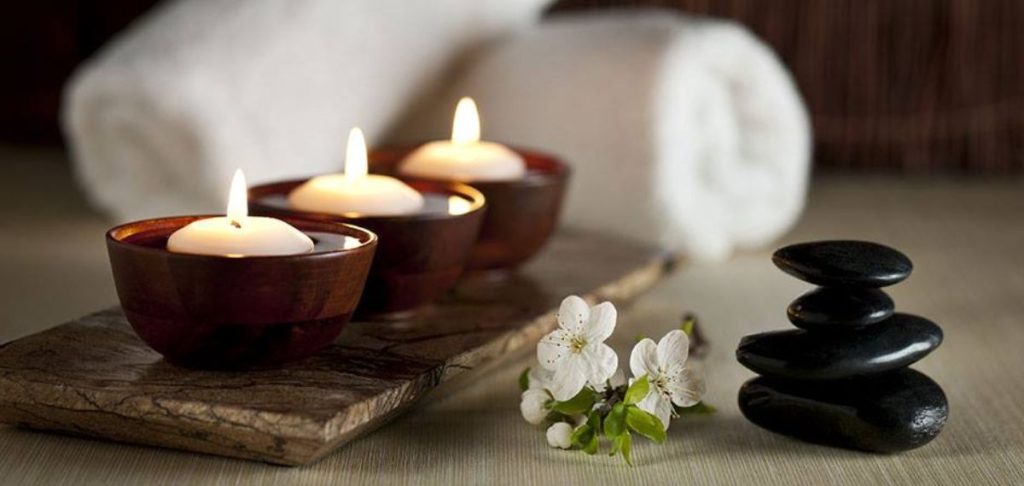 a group of candles in bowls and a towel