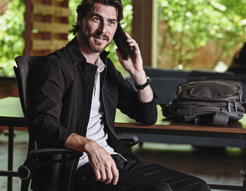 a man sitting in a chair talking on a cell phone