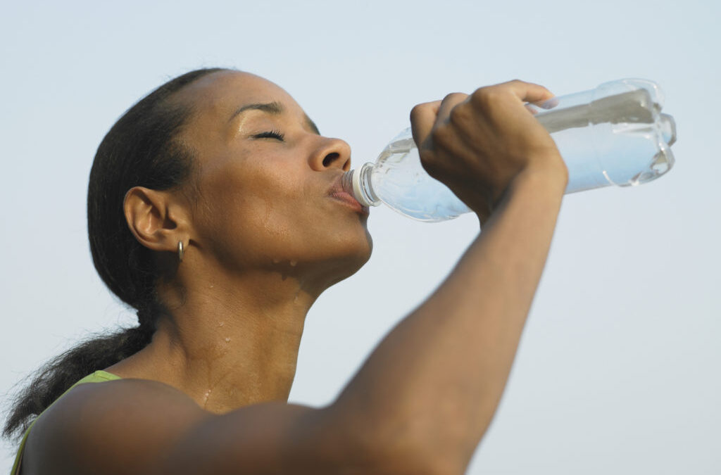 a woman drinking water from a bottle