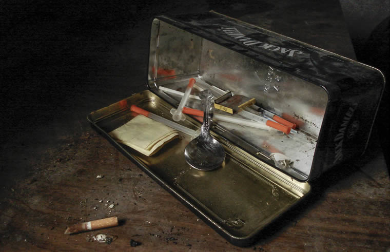 a metal box with a spoon and cigarettes