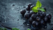 a bunch of black grapes with leaves on top