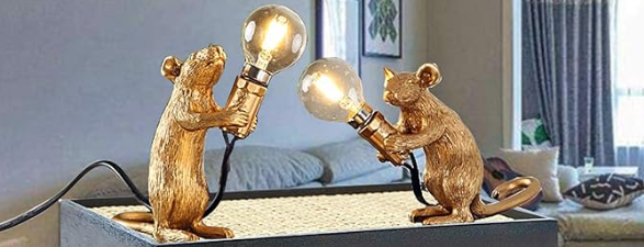 a pair of gold figurines holding light bulbs