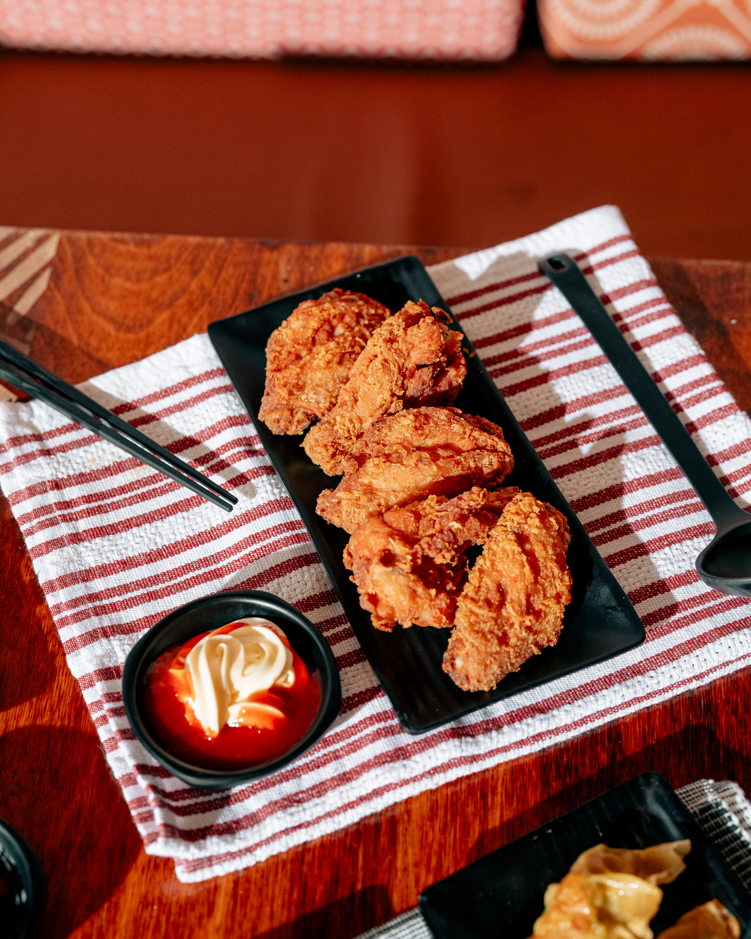 a plate of fried chicken with sauce and spoon on a table