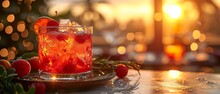 a glass of red liquid with ice and berries on a plate