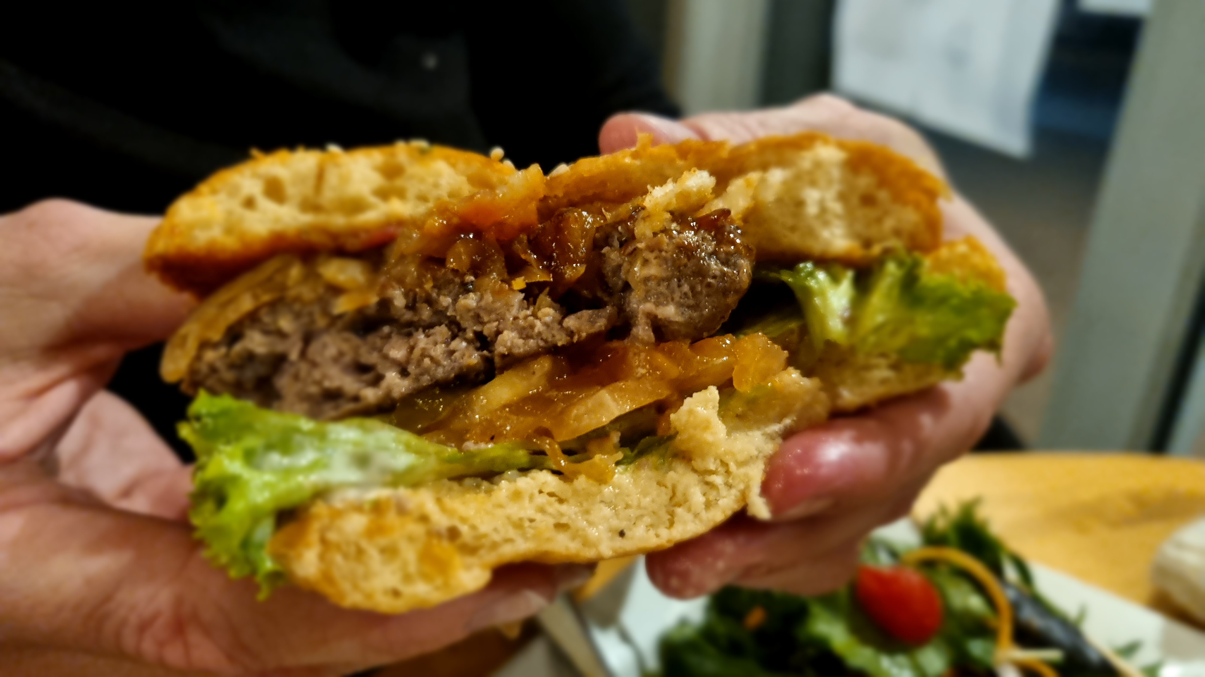 a person holding a burger