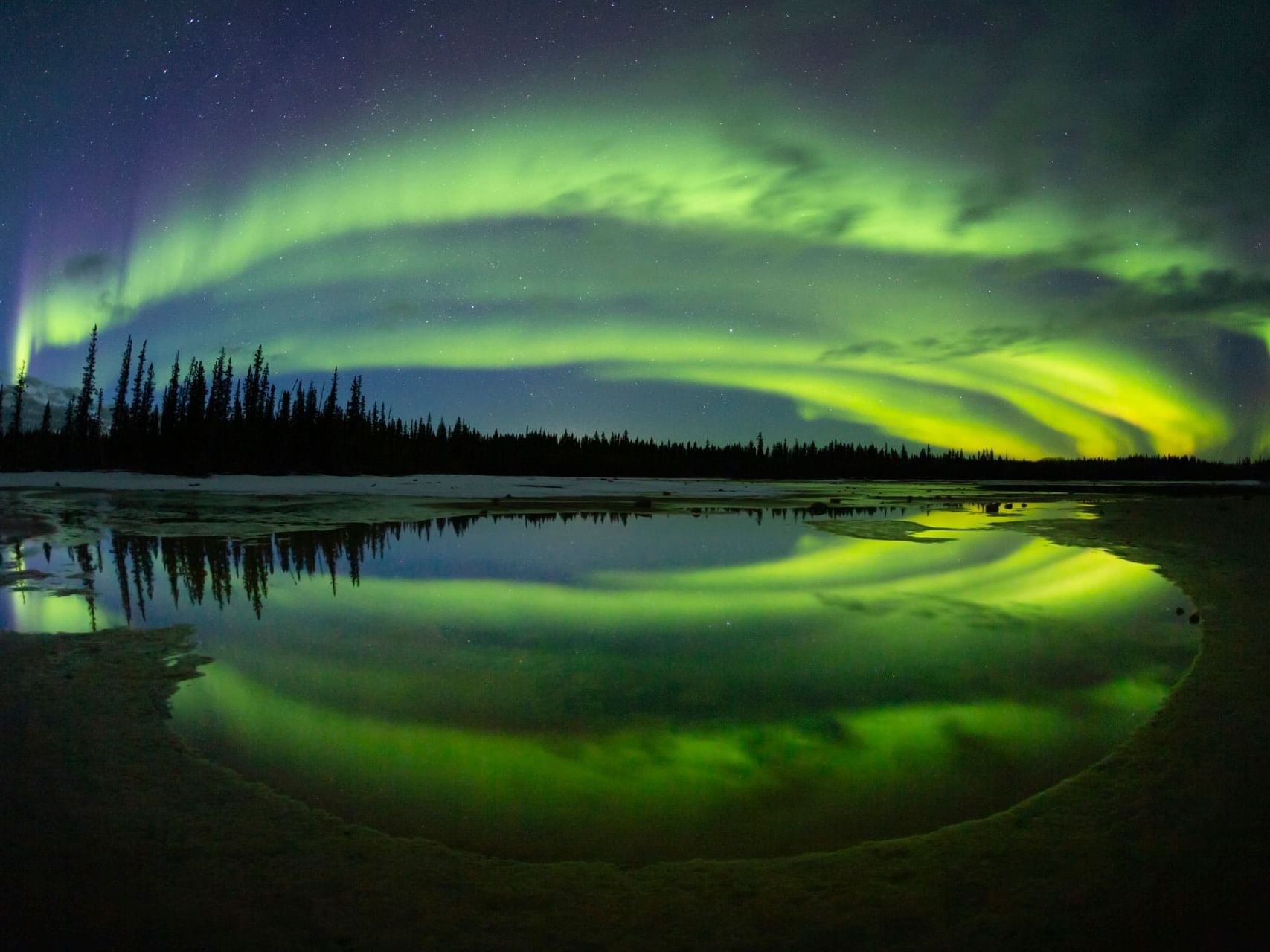 a green lights in the sky over a lake