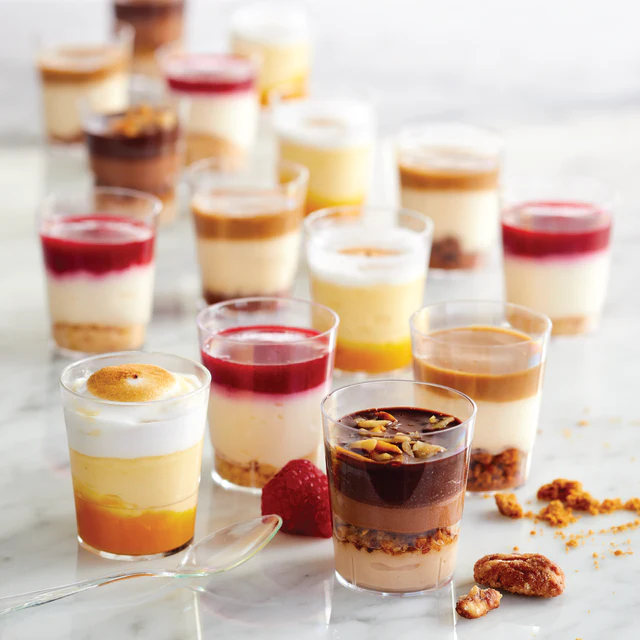 a group of desserts in small glasses