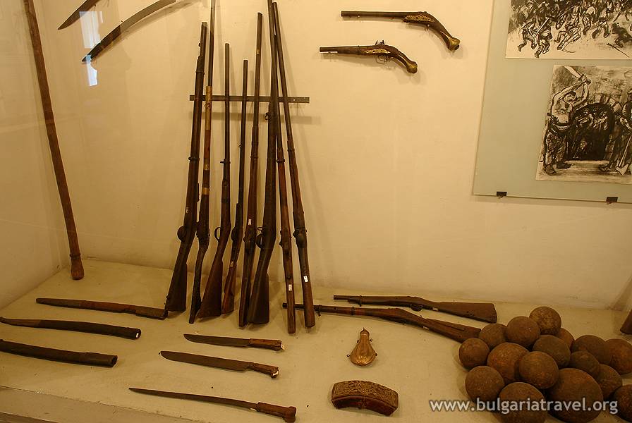 a collection of guns and weapons on a wall