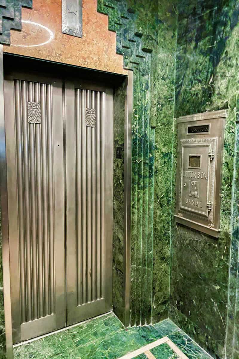 an elevator with a green wall and a metal door
