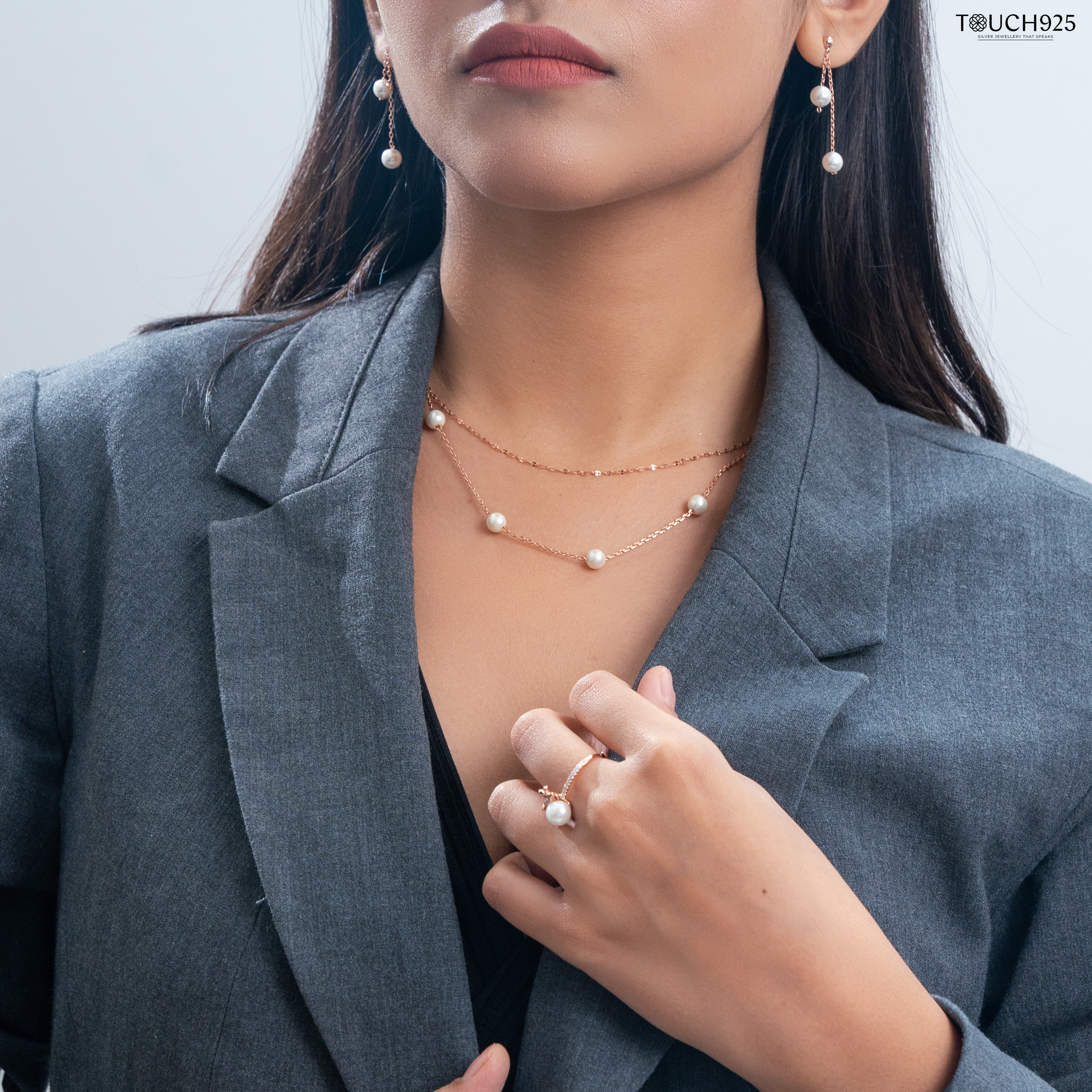 a woman wearing a suit and earrings