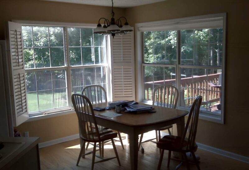 a dining table and chairs in a room with windows