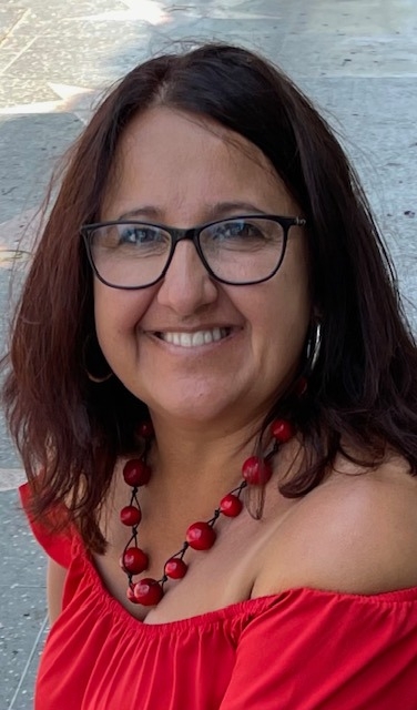 a woman wearing glasses and a red necklace