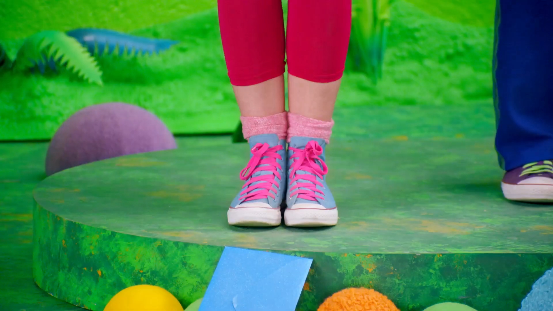 a person's legs in pink and blue shoes