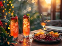 two glasses of fruit and a plate of food on a table