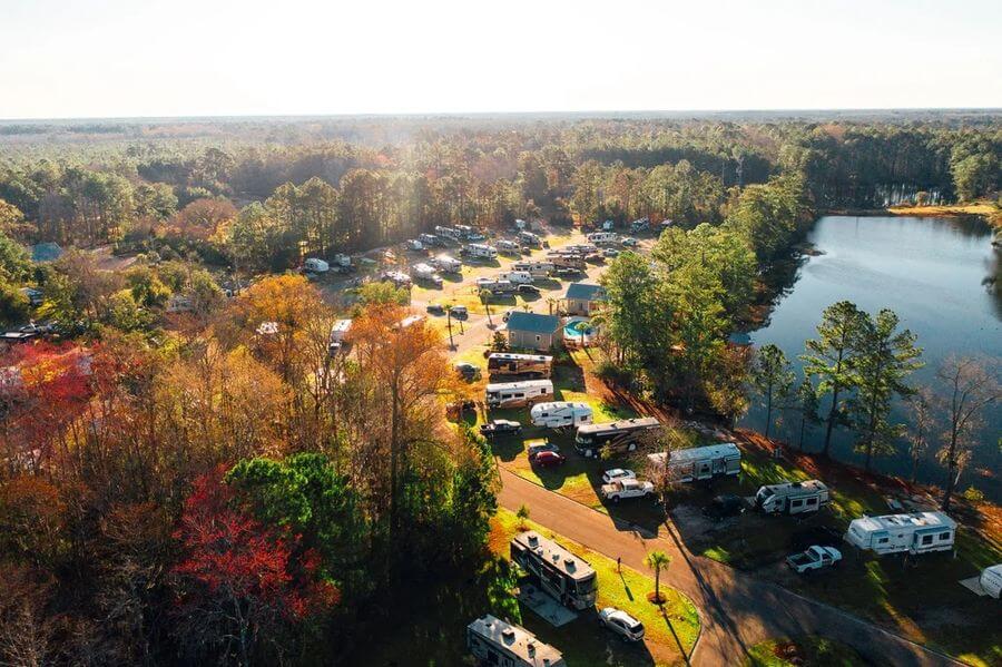 aerial view of a parking lot with cars and a lake