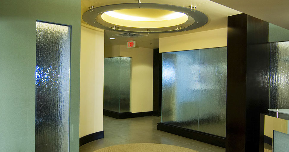 a hallway with glass walls and a round ceiling