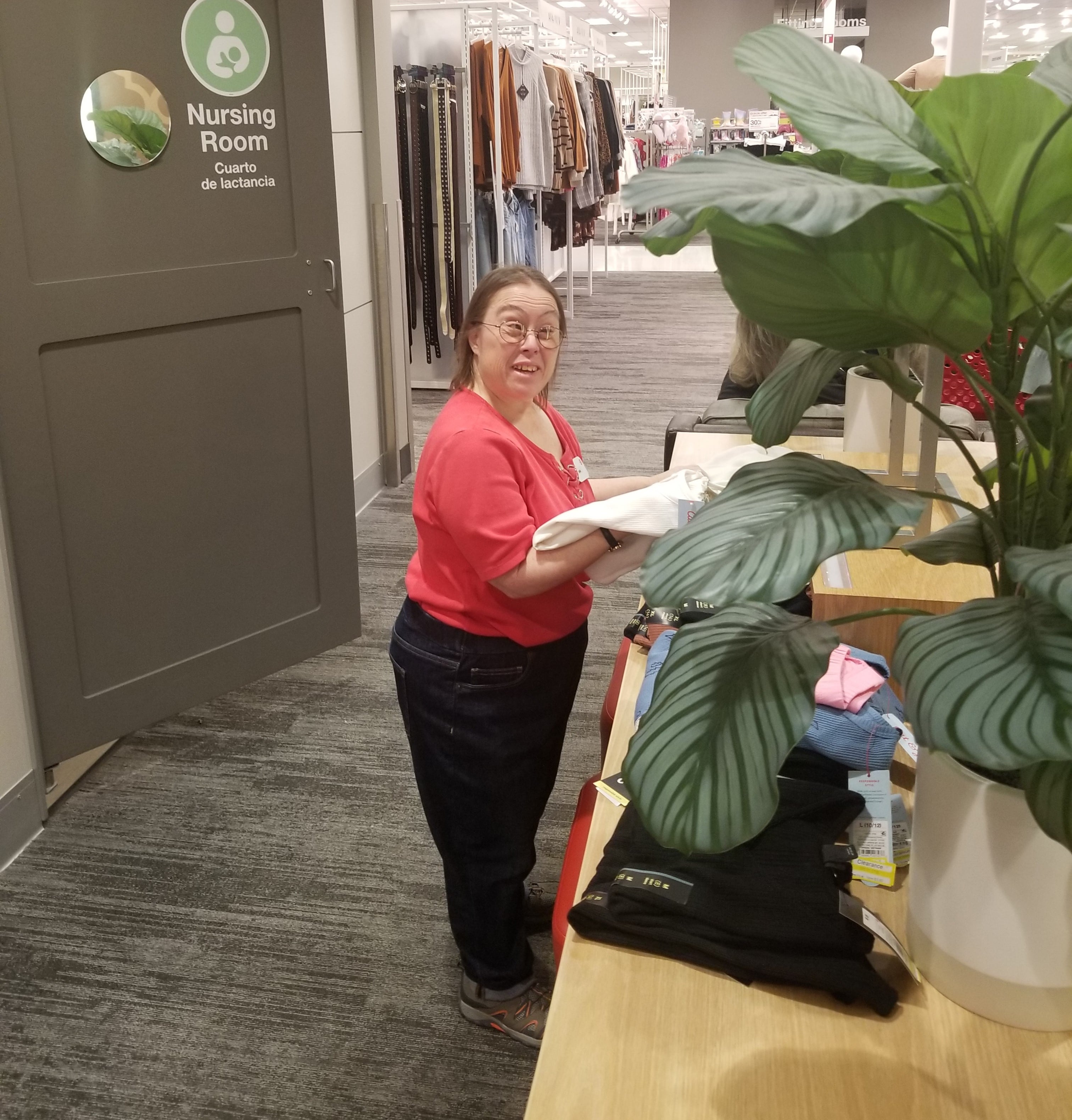 a woman standing in a room with a plant
