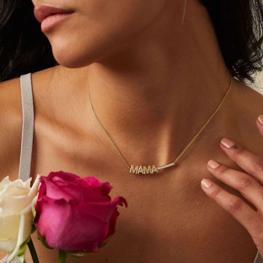 a woman wearing a necklace and holding a rose