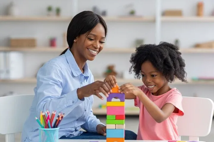 a woman and a child playing with blocks