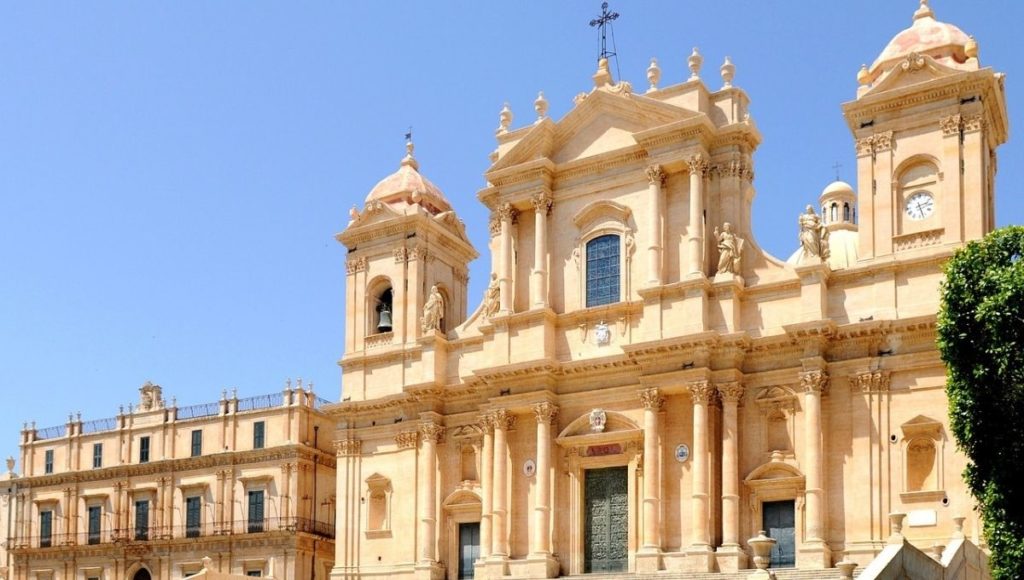 a large building with a large door and a bell tower