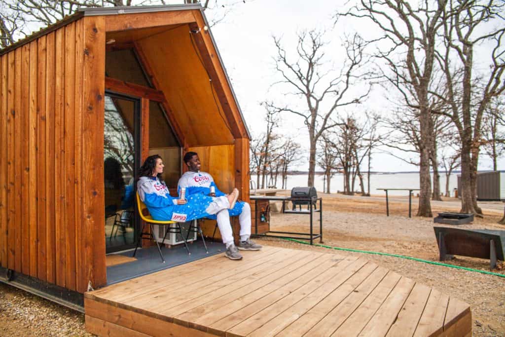 a man and woman sitting on a porch outside