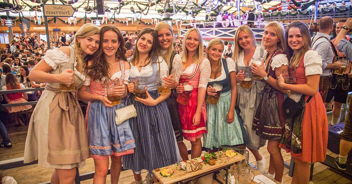 a group of women holding glasses of beer
