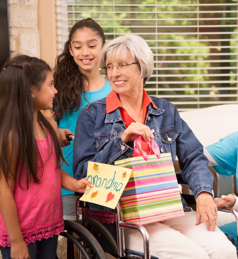 a woman in a wheelchair with a bag and a group of girls
