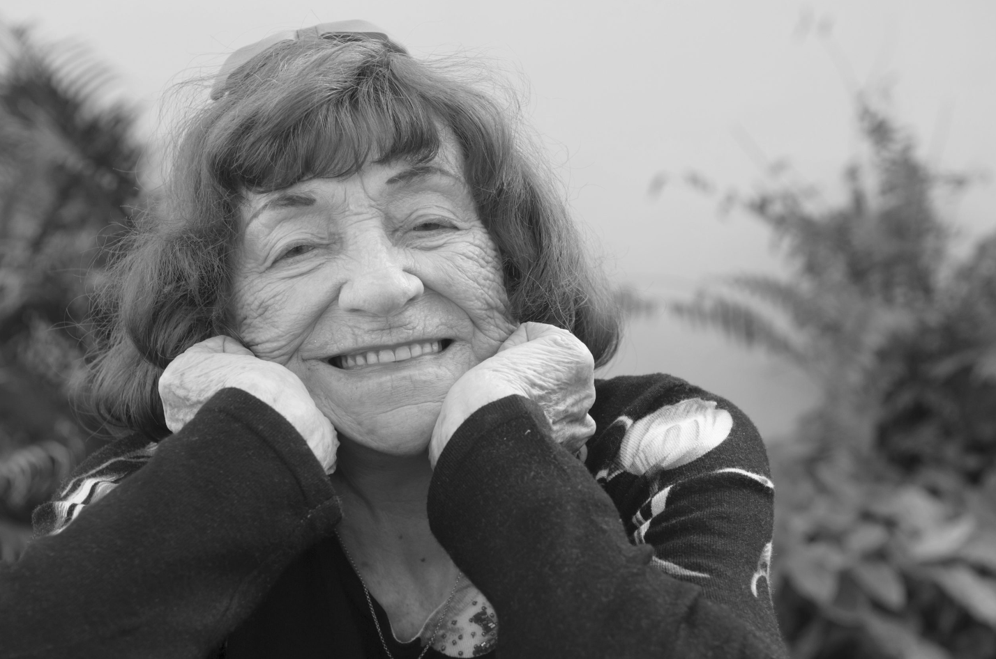 a woman smiling with her hands on her cheeks