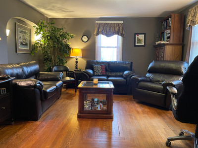 a living room with leather couches and a wood floor