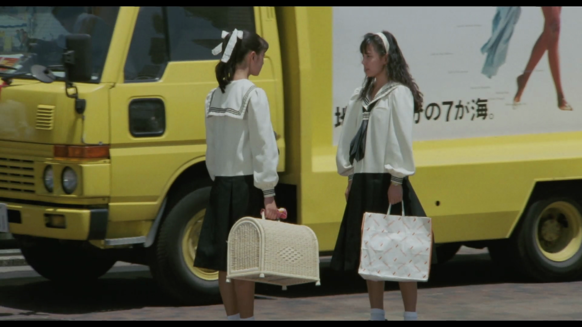 a couple of girls in school uniforms carrying a bird cage