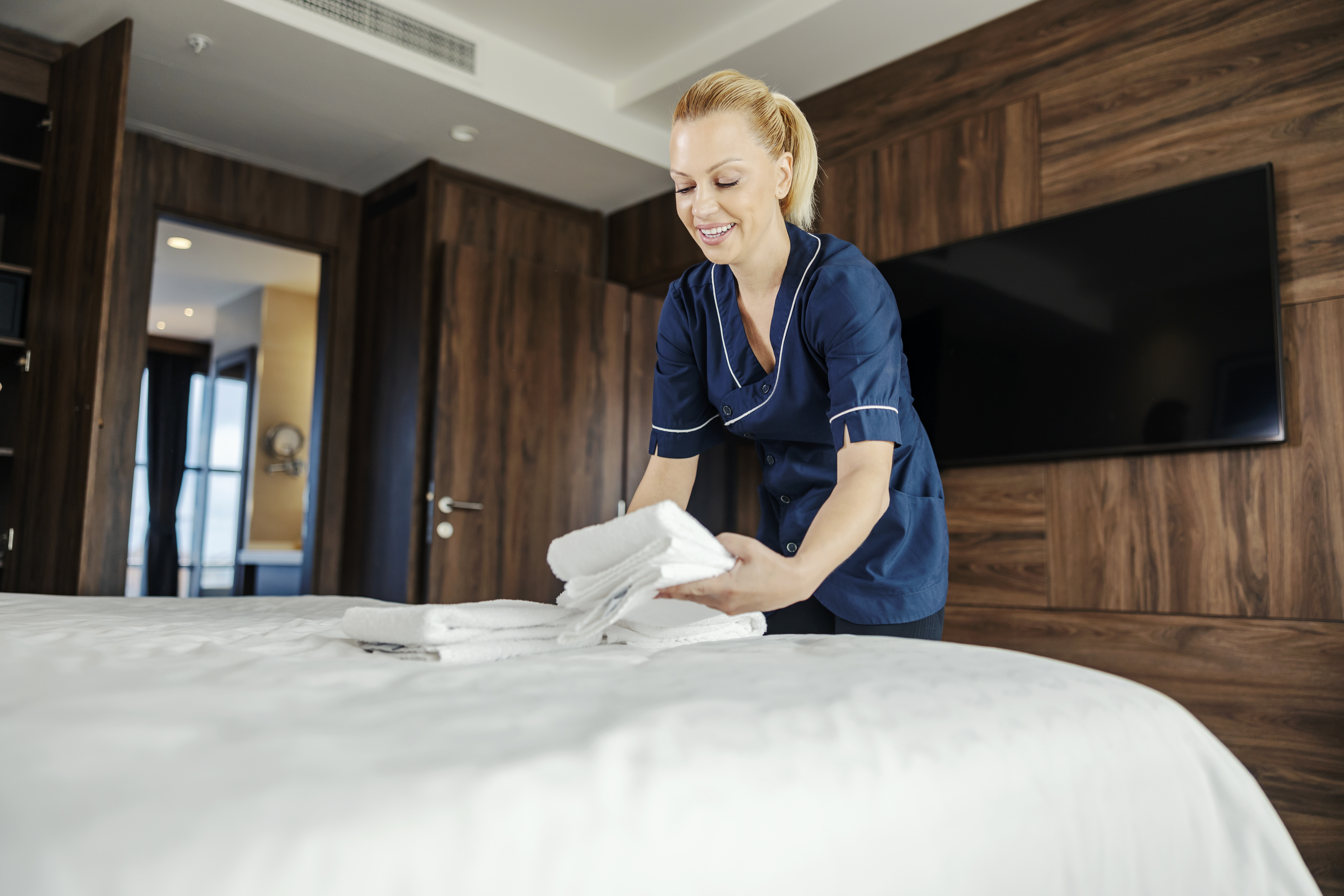 a woman folding towels on a bed