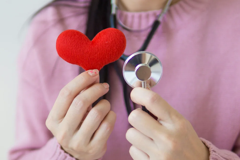 a person holding a heart and a stethoscope