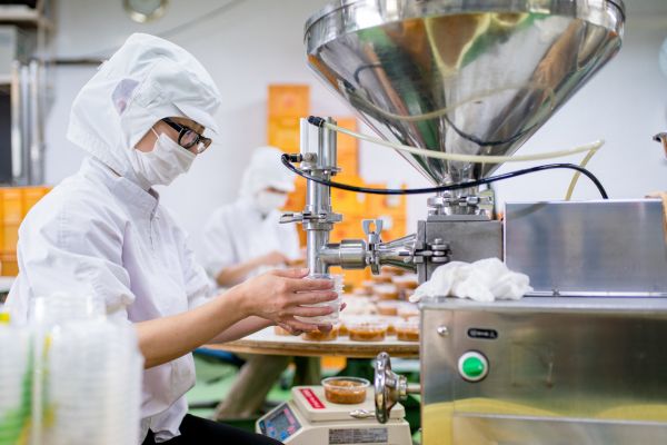 a person in white protective gear working in a factory