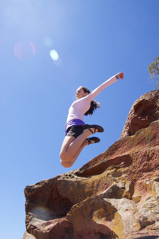 a woman jumping off a cliff