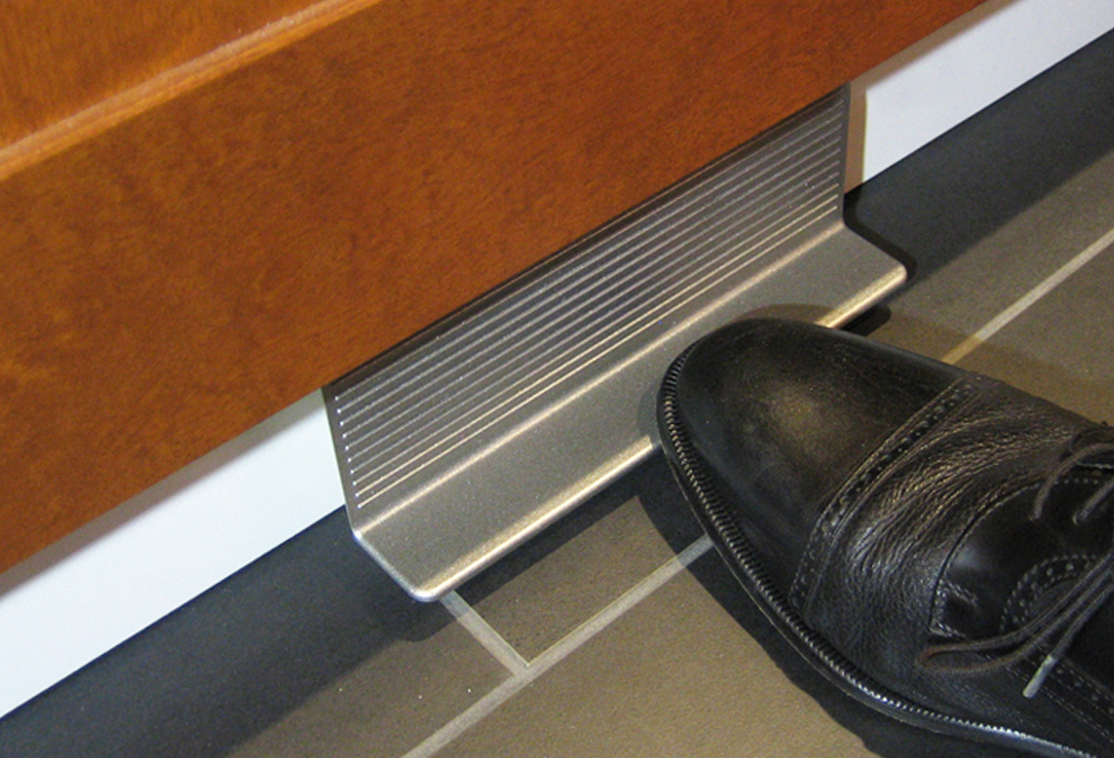 a black shoe next to a metal object