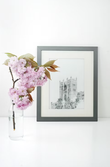 a picture frame and a vase with pink flowers