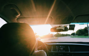 a sun shining through the windshield of a car