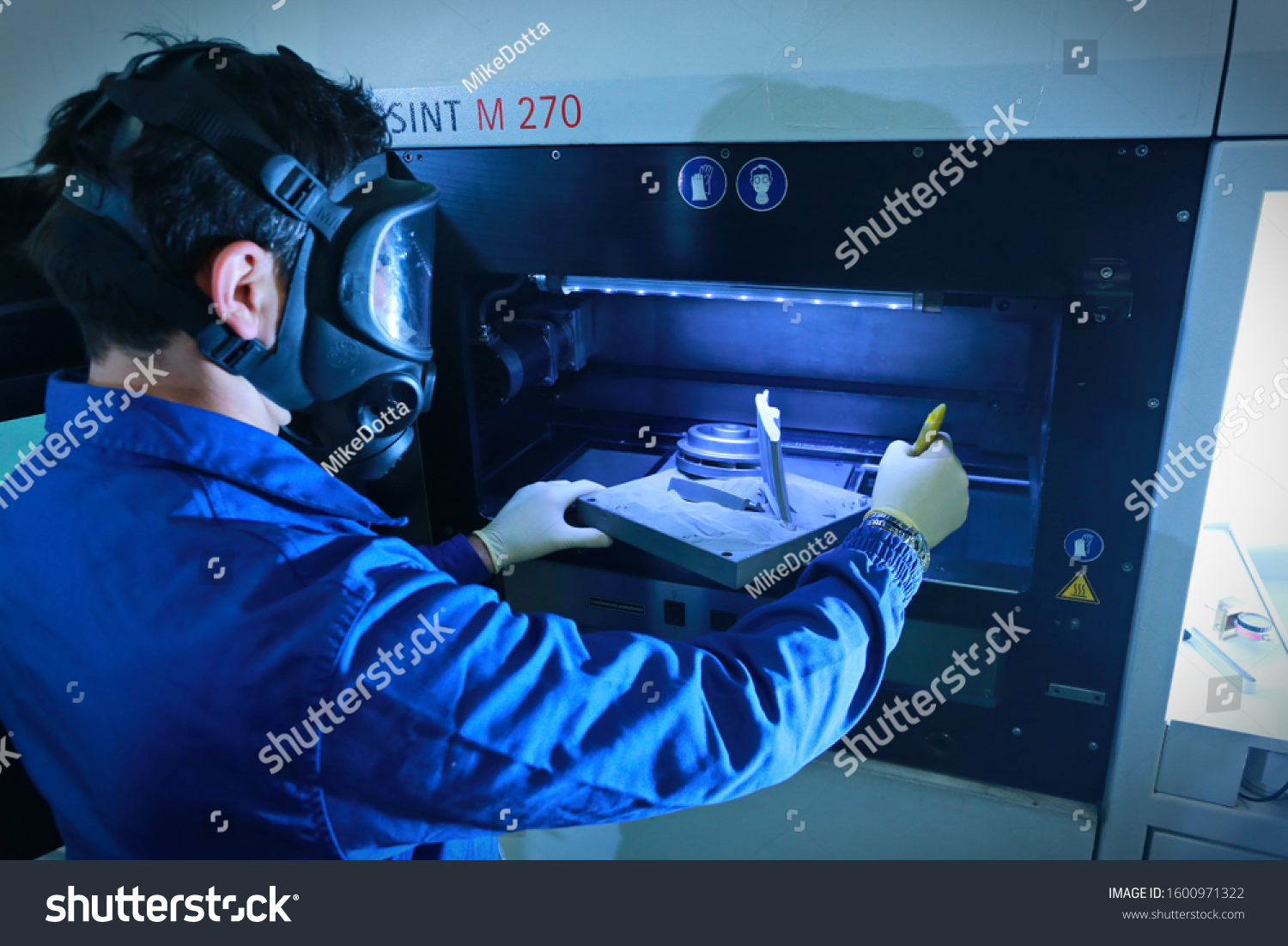 a man wearing a mask and gloves working in a machine