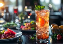 a glass of liquid with ice and orange slices on a table