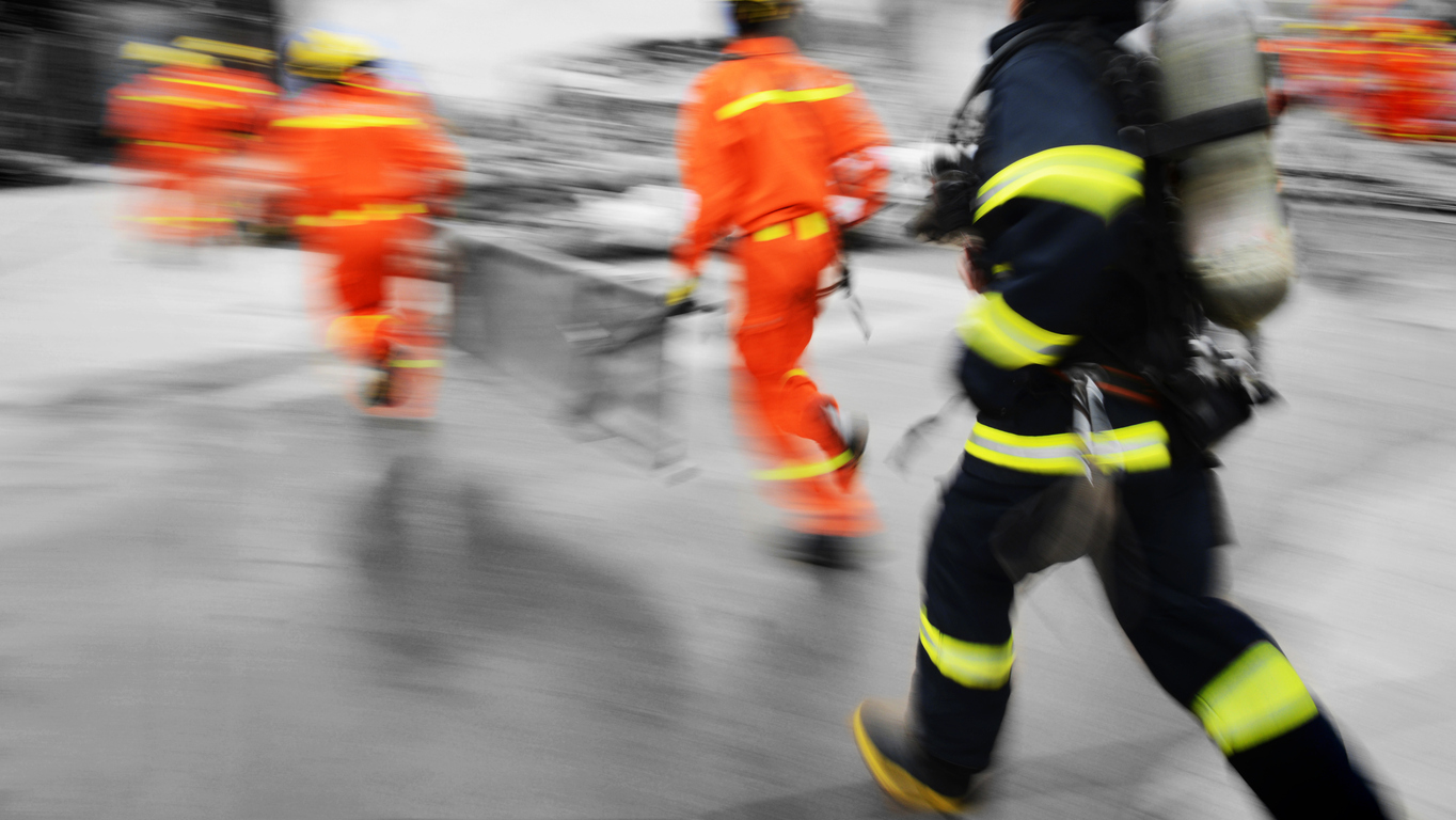 a blurry image of a group of firefighters walking on a street