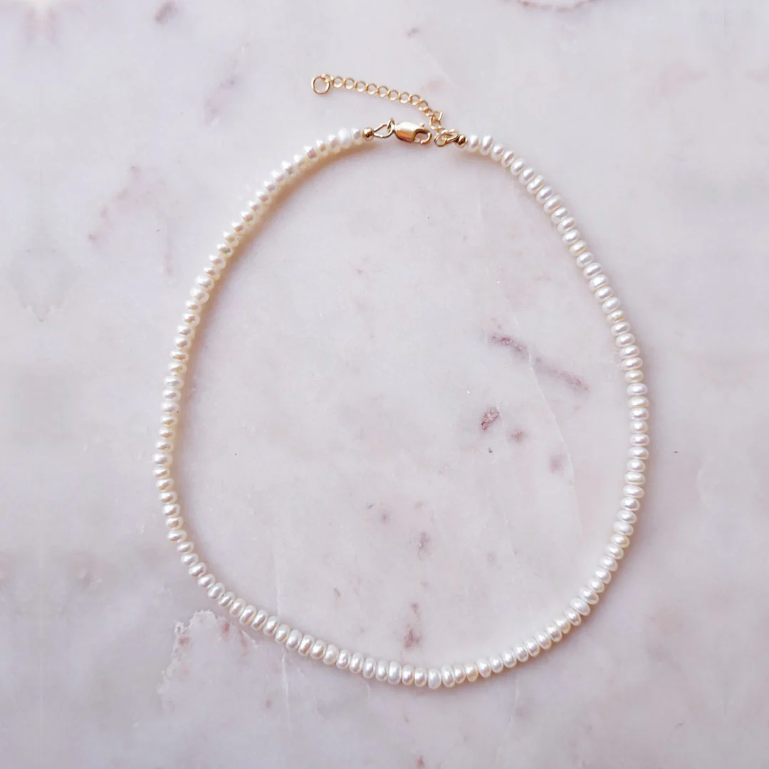 a pearl necklace on a marble surface
