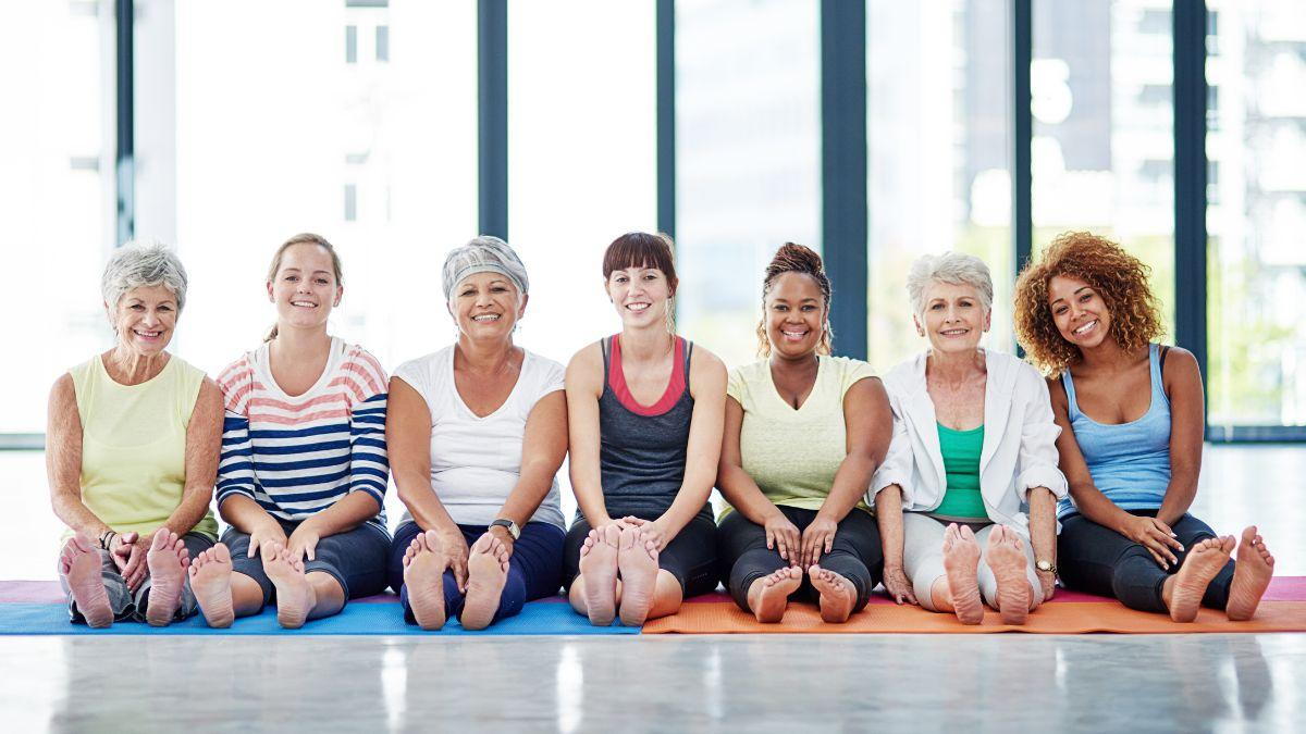 a group of women sitting on a yoga mat