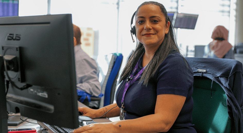 a woman wearing a headset and sitting at a computer