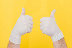 a pair of hands wearing white gloves