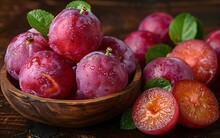 a bowl of plums and a cut plum